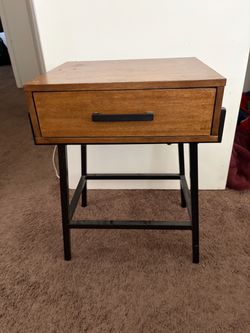 Small wood and black side table with one drawer and bottom shelf