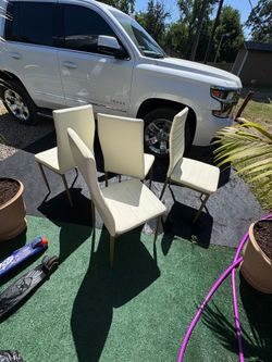 Gold table with 4 white chairs and new throw pillows