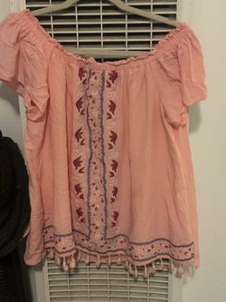 Pink off-shoulder top with floral embroidery and tassel