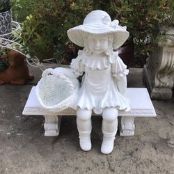 Cute little girl on bench garden statue