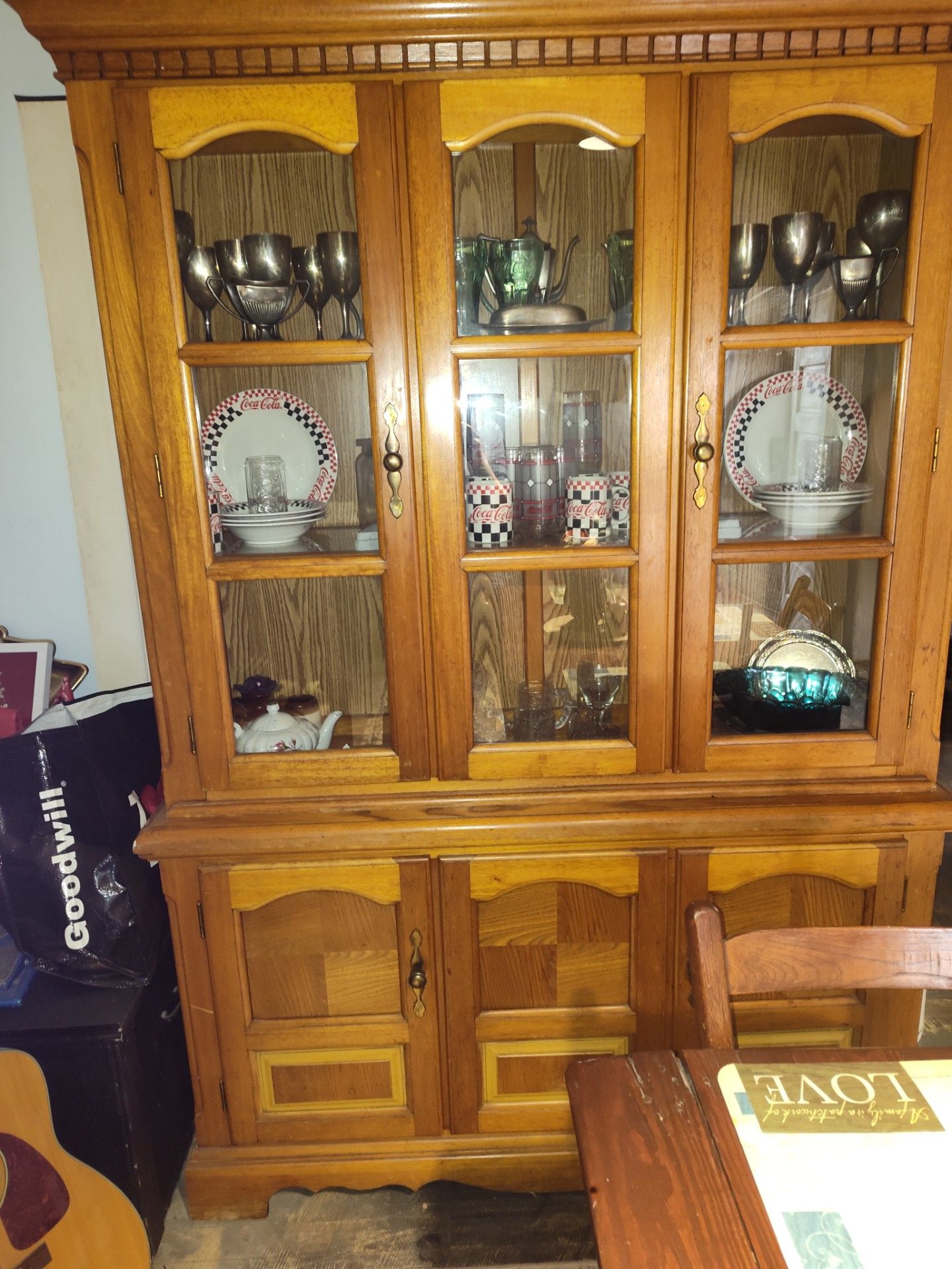 China hutch full of silver and coca cola collector items