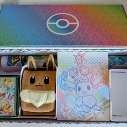 Pokémon Prismatic Evolutions Box, an Eevee Deck Box, Playmat Featuring Eevee and Evolutions, and Sleeves