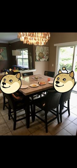 verview This is a dining room set featuring a rectangular faux marble top table and black upholstered chairs.