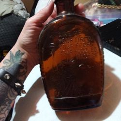  Bicentennial bottle featuring an embossed Statue of Liberty and the famous quote "Give me your tired, your poor, your huddled masses". 
Manufacturer: