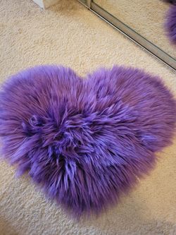 Heart purple rug appears to be a faux sheepskin decorative mat, often used for adding texture to chairs or small floor spaces.