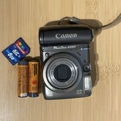 Canon Powershot A590is digital camera Tested Works  flash zoom video photo all working. Batteries and memory card included. Camera door doesnt seem to