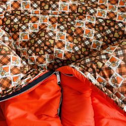 Vintage ‘76 Coleman sleeping bag Bright orange 100 % nylon outside that reverses to plaid patchwork 100 % cotton soft fabric in retro orange / brown 
