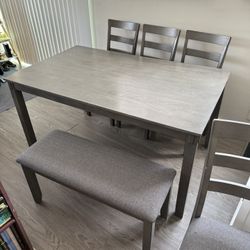 Gray Table, 4 Cushioned Chairs, and Bench