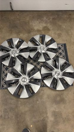 Tesla Model Y OEM  Silver Gemini hubcaps and OEM Black Carpet Floor Mats