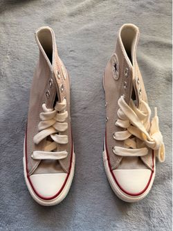 beige Converse Chuck 70 high-top sneakers with a signature red stripe along the rubber