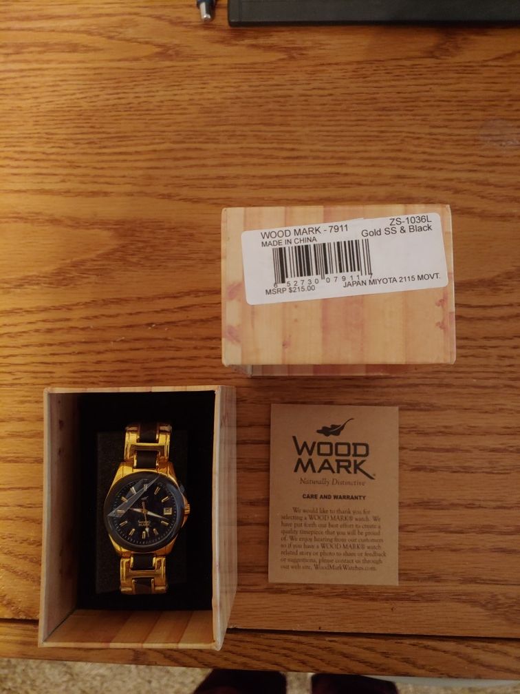 Women's gold watch with black trim.