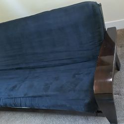 Futon, solid brown wood frame, black cloth cover. Heavy duty, good quality.