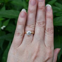 1.05 CT lab-grown round solitaire engagement ring in 14K yellow gold with white gold prong tips. Includes IGI report.