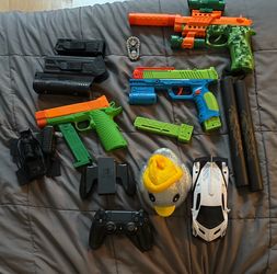 Play guns, ps4 controller with charger, foam nunchucks, toy car, rubber duck