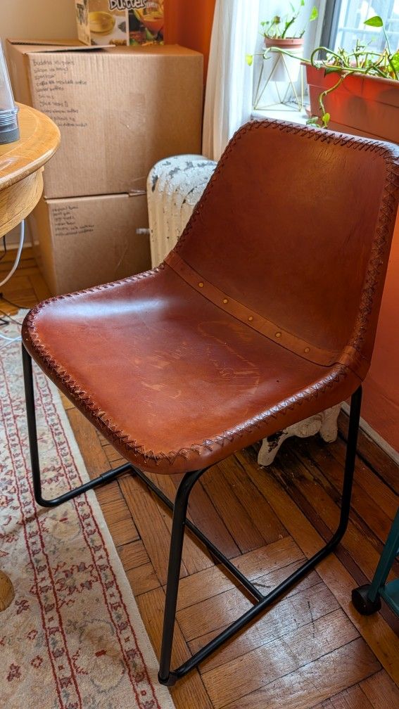Two CB2 leather dining/accent chairs