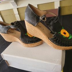 black leather Mexican artisanal huarache sandals with a woven wedge heel and sunflower embroidery