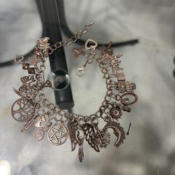 “A Wiccan bracelet with amulets. The pentagram, the tree of life, the owl, the cat, the dagger, the goblet and other symbols. Ideal for pagans or as a