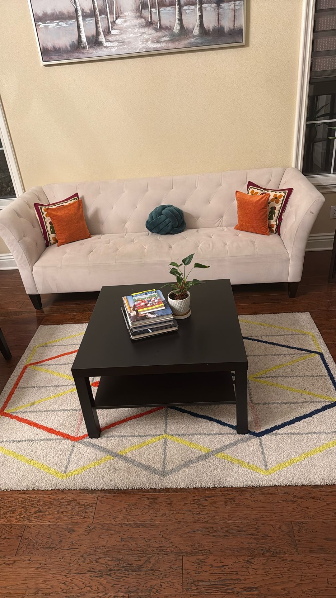 Elegant white tufted sofa with colorful cushions.