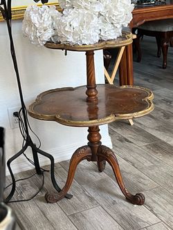 ntique two-tier “dumbwaiter” or side table with these value-driving features:  * Wood: Likely mahogany or a mahogany veneer * Design: Pie-crust (scall