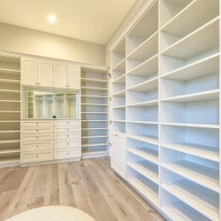 Master Walk-In White Closet with Raised Drawer Front Panels, Mirror Above the Drawers and Doors Above the Mirror, Hamper Included. Everything is adjus