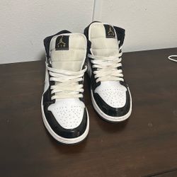 Air Jordan 1 Mid SE Patent Black White Gold sneakers.