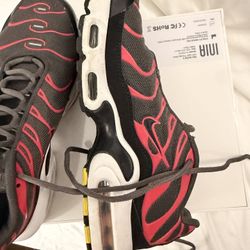 These are Nike Air Max Plus GS sneakers in the Medium Ash/Siren Red colorway.  