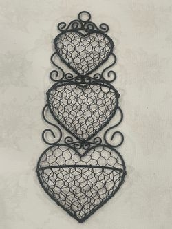 Black wire wall organizer with three stacked heart-shaped baskets. 19”