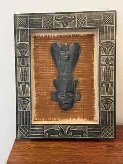 Carved wooden mask in decorative frame, 12x15 inches.