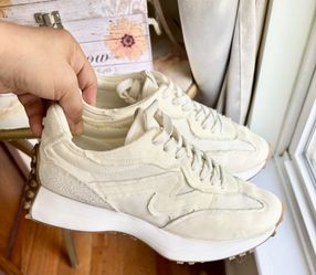 Stylish cream sneakers with tan accents. Ideal for casual wear. Comfortable and trendy design. In excellent condition size 7.5