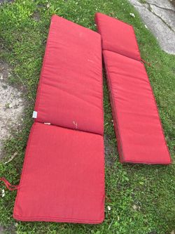 Two red used patio lounge chair cushions