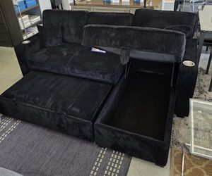 Black corduroy sectional sofa with pullout sleeper bed with cup holders 