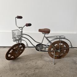 DecMode silver metal bike decorative sculpture with brown wood wheels.