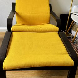 Comfortable yellow lounge chair with dark wooden frame. 