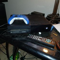 Black Xbox One And All The Cords And Blue Controller 