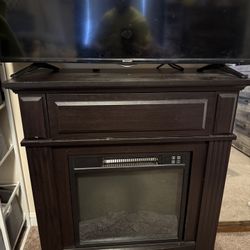 Electric fireplace with shelf, has marks on the corners from our pup other than that the fireplace lights and heating element work as they should! $30