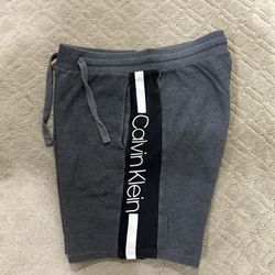 Men Calvin Klein grey logo jogger shorts size M Grey shorts featuring side pockets, elastic waistband with drawstring, back pocket, side logo graphic 