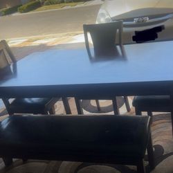 Dining table with 4 chairs and a bench.