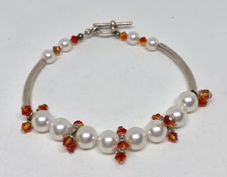 Silver tone bracelet with white pearls and orange glass seeds