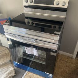 Smart Freestanding Electric Range, model NE63A6751SS/AA. This appliance features a stainless steel design with a black glass cooktop and oven door. It