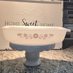 Vintage Dynaware Pyr-O-Rey casserole dish, likely from the 1960s or 1970s. It's made of white milk glass with a brown daisy pattern