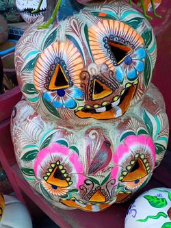This item is a hand-painted Mexican Clay jack-o'-lantern tower, which merges traditional Mexican pottery artistry with festive Day of the Dead (DÃa d