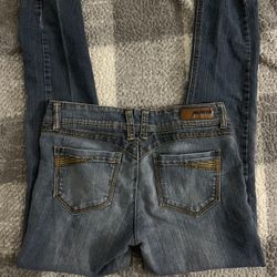 Women's blue denim jeans with a "Rewind" brand patch.