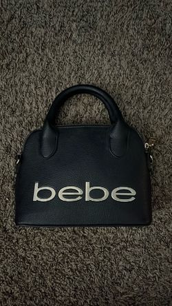 Black Bebe Purse w/ a golden color zipper and w/ the purse strap
