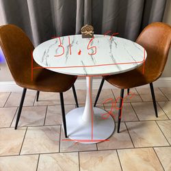 White round marble table with two brown chairs.