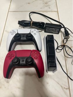 Red and white dualsense ps5 controllers with charging station