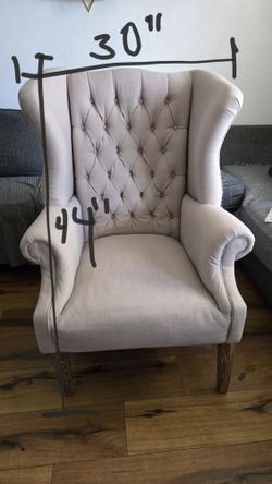 Beige upholstered wingback armchair