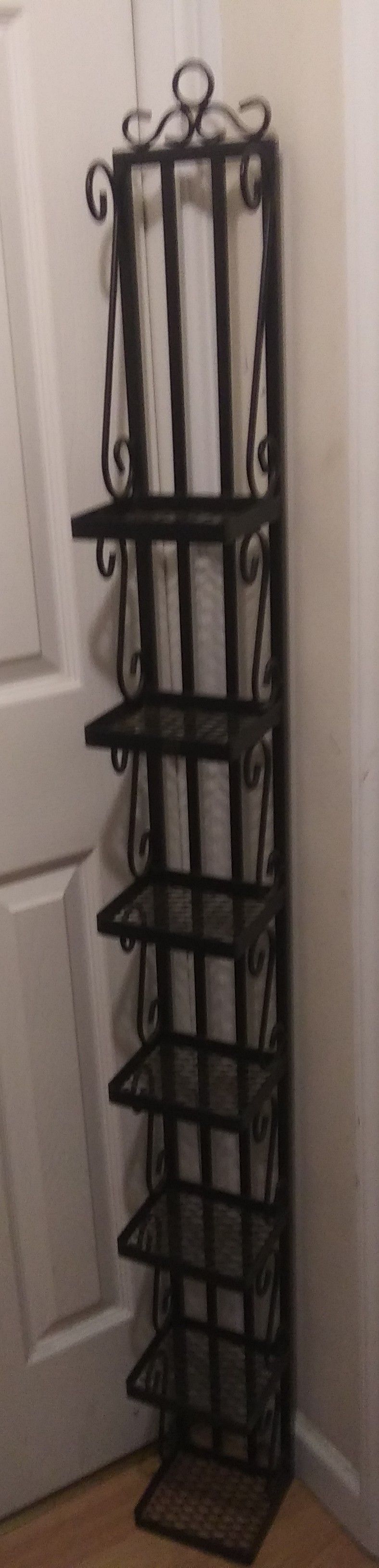 Tall metal like shelf with 7 small shelves with pretty decorations on either side