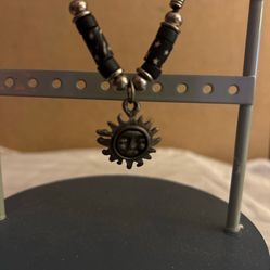Sun necklace with black, silver, and black star pattern beads