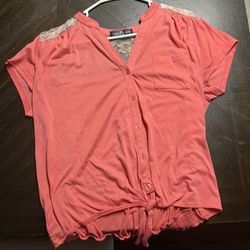 This item is an Almost Famous women's coral short-sleeve button-front shirt with lace shoulder 