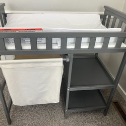 gray changing table with hamper and shelves 